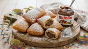 Bugie di Carnevale ripiene di Nutella su un tagliere con zucchero a velo e coriandoli