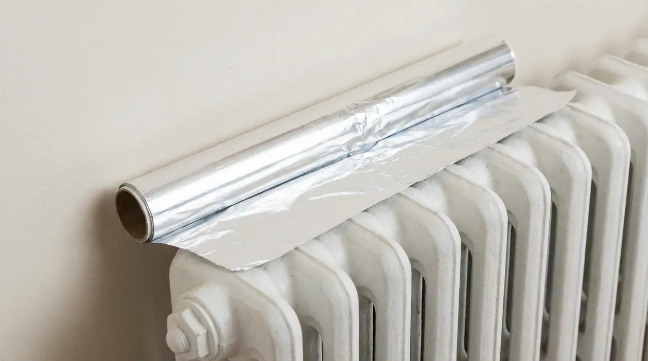 Rotolo di carta stagnola posizionato sopra un termosifone bianco