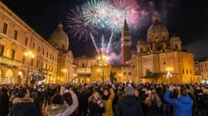 Persone riunite in piazza per i fuochi d'artificio di Capodanno davanti a edifici storici illuminati